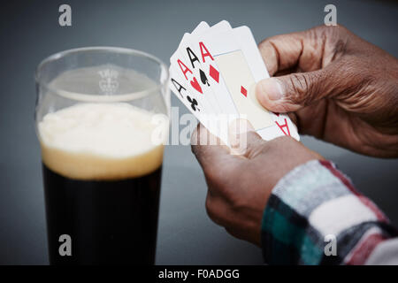 Mann mit vier Ace Karten mit Bier Stockfoto