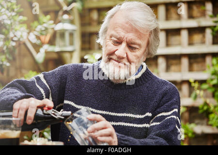 Senior woman Gießen Bier Stockfoto