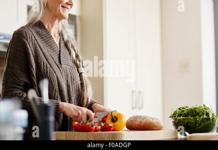 Ältere Frau, die Zubereitung von Speisen in der Küche Stockfoto