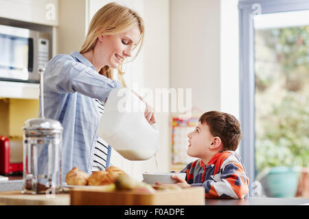 Mutter Sohn Frühstück Schüssel Milch überfluten Stockfoto