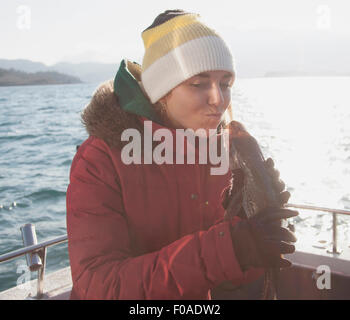 Junge Frau mit Fisch auf Boot Stockfoto