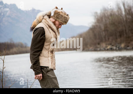 Mitte erwachsenen Mannes Trapper Hut durch Fluss Stockfoto