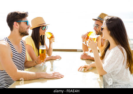 Freunde, Spaß und trinken ein kühles Bier an der Strandbar Stockfoto