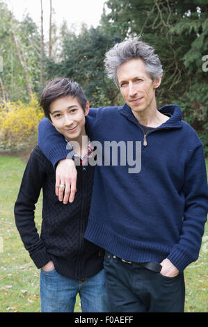 Porträt von reifer Mann und Sohn im Teenageralter im Garten Stockfoto