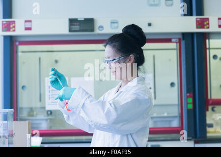 Wissenschaftlerin im Labor Pipettieren Probe ins Labor Becher Stockfoto