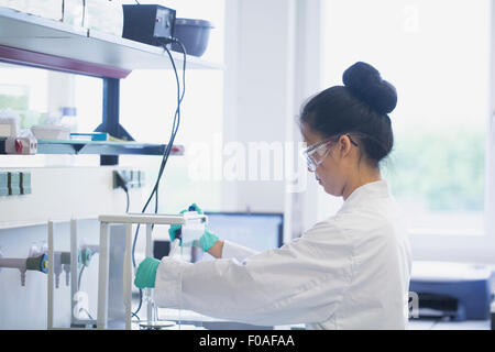 Junge Wissenschaftlerin im Labor mit Hilfe wissenschaftlichen Geräte Stockfoto