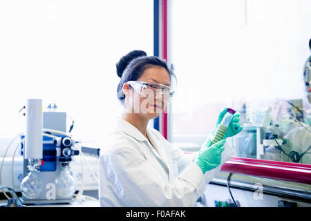 Porträt der jungen Wissenschaftlerin Blick auf Probe im Labor Stockfoto