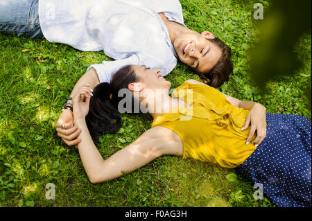Erhöhte Ansicht des jungen Paares liegen auf dem Rasen Stockfoto
