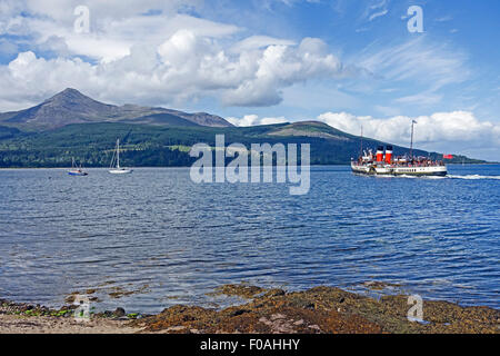 Die Strandpromenade von Brodick in Arran Schottland mit Paddel-Dampfer Waverley verlassen die Pier und Bergziege fiel nach links. Stockfoto