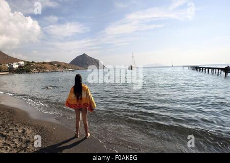 Rückansicht der Frau auf Karaincir Strand, Bodrum, Türkei Stockfoto