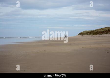 Ein paar wenige auf einer menschenleeren Weiten weitläufigen Strand in North East England. Stockfoto