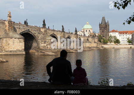 Prag, Tschechien - 14. Mai 2011: Mann und Kind Blick über die Moldau an der Karlsbrücke in Richtung Altstadt. Stockfoto