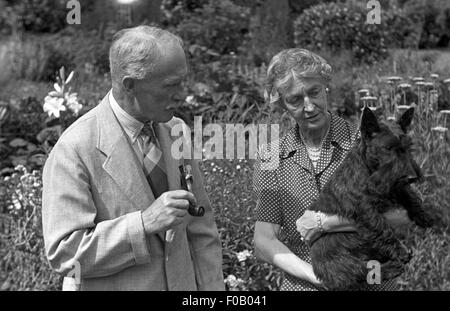 Ein paar mit ihren schottischen Terrier Hund stehend in einem Garten Stockfoto