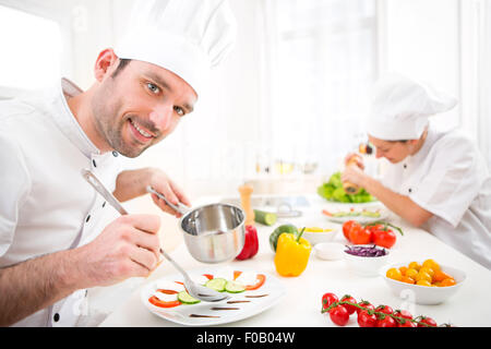 Blick auf eine junge attraktive Profi-Koch in seiner Küche kochen Stockfoto