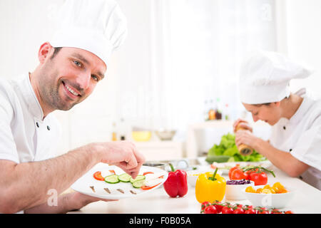 Blick auf eine junge attraktive Profi-Koch in seiner Küche kochen Stockfoto