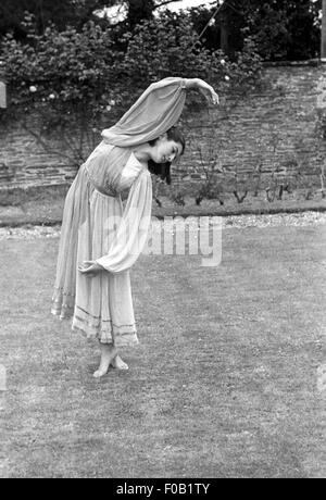 Eine junge Frau in einem Garten tanzen Stockfoto