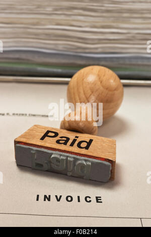 ein Stempel mit der Aufschrift bezahlt ist auf einer Rechnung Stockfoto