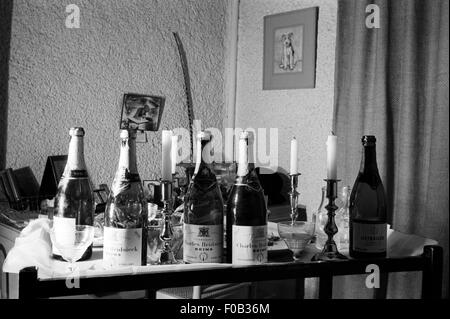 Leere Flaschen Champagner, aufgereiht auf einem Tisch nach einer Feier. Stockfoto