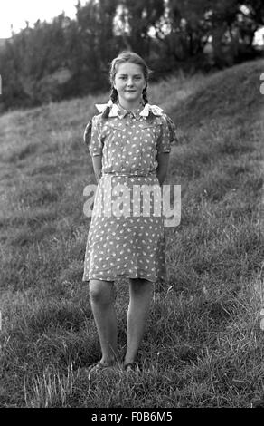 Ein Mädchen trägt ein Kleid steht in einem Feld. Stockfoto