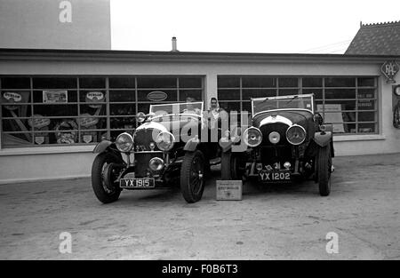 Zwei Frauen sitzen im hinteren Teil ein Bentley Auto neben einem anderen Bentley außerhalb einer garage Stockfoto