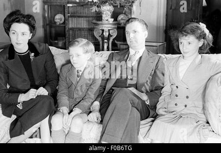 Ein Familienfoto mit Mutter, Vater, Sohn und Tochter auf einem Sofa sitzt. Stockfoto