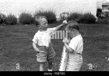 Zwei junge Burschen, die Eröffnung einer Parzelle im Garten. Stockfoto