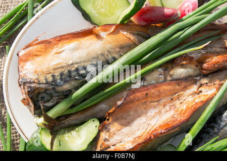 geräucherten Fisch mit einer Vielzahl von Gemüse auf einem Teller Stockfoto