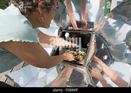 Frau Kochen squash Gericht in einem Solarofen. Stockfoto
