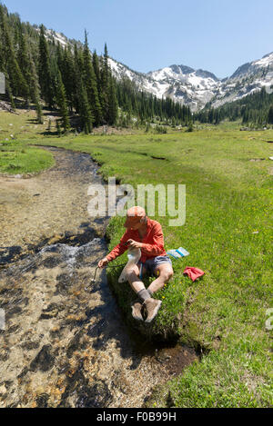 Backpacker, die Filterung von Wasser in den Wallowa Bergen, Oregon. Stockfoto
