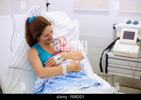 Mutter, die Geburt eines Babys. Neugeborenen im Kreißsaal. Mutter ihr neugeborenes Kind nach Arbeit zu halten. Stockfoto