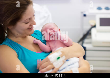 Mutter, die Geburt eines Babys. Neugeborenen im Kreißsaal. Mutter ihr neugeborenes Kind nach Arbeit zu halten. Stockfoto