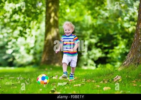 Glückliches Kind spielen Fußball im Freien im Schulhof. Kinder spielen Fußball. Aktiv Sport für Vorschulkind. Stockfoto