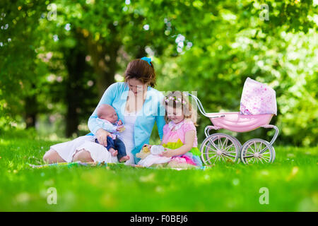 Familie mit Kindern, Picknick im Freien zu genießen. Mutter mit Säugling und Kleinkind Kind entspannen Sie in einem Park. Stockfoto