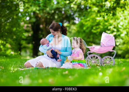 Familie mit Kindern, Picknick im Freien zu genießen. Mutter mit Säugling und Kleinkind Kind entspannen Sie in einem Park. Stockfoto