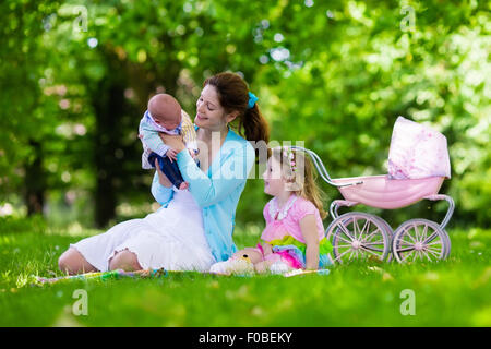 Familie mit Kindern, Picknick im Freien zu genießen. Mutter mit Säugling und Kleinkind Kind entspannen Sie in einem Park. Stockfoto