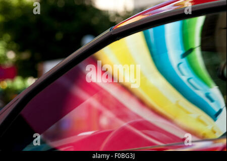 Autos parken auf Parkplatz mit Farben reflektiert auf Windschutzscheibe und Auto Motorhaube Stockfoto