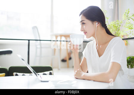 Glückliche junge Frau Musikhören im Coffee-shop Stockfoto