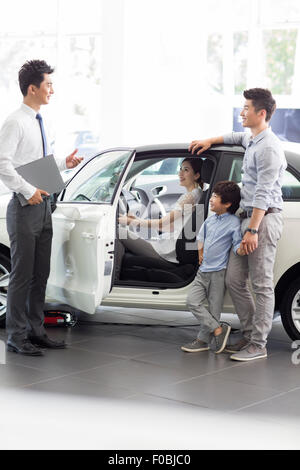 Junge Familie Wahl Autos im showroom Stockfoto