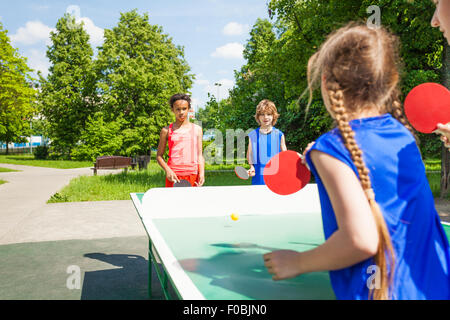 Vier internationale Freunde spielen Tischtennis Stockfoto