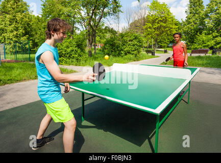 Afrikanische Mädchen und Jungen spielen Pingpong außerhalb Stockfoto