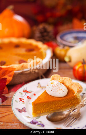 Hausgemachte Kürbis-Kuchen auf einem rustikalen Tisch mit herbstlichen Dekorationen. Stockfoto