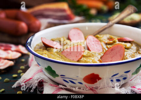 Herzhafte traditionelle holländische Erbsensuppe mit geräucherter Wurst, Roggenbrot und Speck. Oder: 'Erwtensoep met Rookworst, Roggebrood En Spek'. Stockfoto