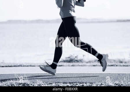 Frau konkurrieren in der Marathon-Rennen auf der Küstenstraße Stockfoto