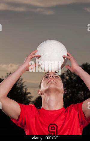 Junge Fußballer Ausgleich Ball auf Kopf Stockfoto