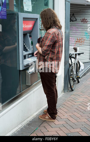 Frau bei einem Santander ATM in der Einkaufsstraße Stockfoto