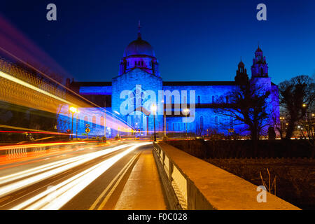 Kathedrale von Galway nachts blau beleuchtet und Auto leuchtet Wanderwege Stockfoto