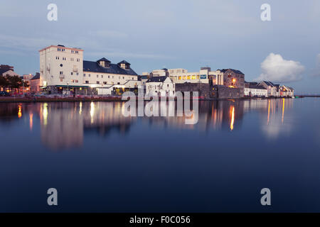 Gebäude am Ufer des Flusses während der Flut in der Stadt in der Dämmerung. Claddach, Galway, Irland. Stockfoto