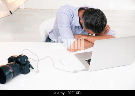 Fotografen, die an seinem Arbeitsplatz im Studio schlafen Stockfoto