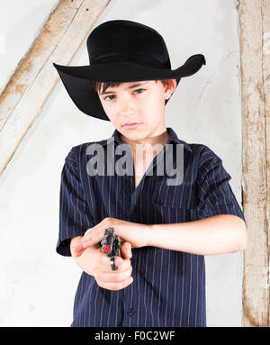 kleiner Junge gekleidet wie ein Cowboy mit Hut und Pistole Stockfoto