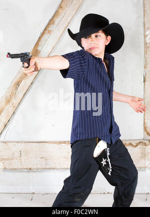 kleiner Junge gekleidet wie ein Cowboy mit Hut und Pistole Stockfoto